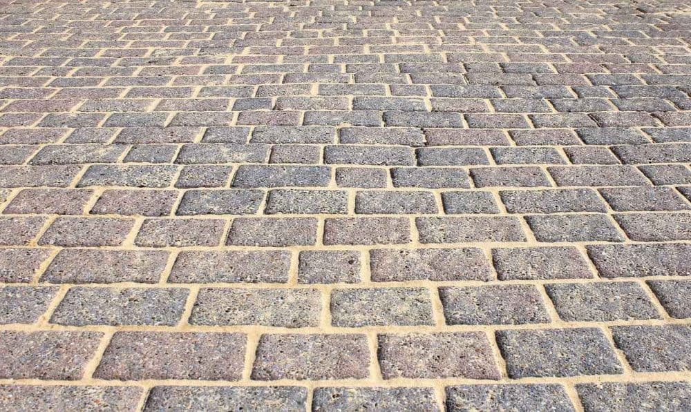 a brick patio with sand between the bricks to prevent weed growth