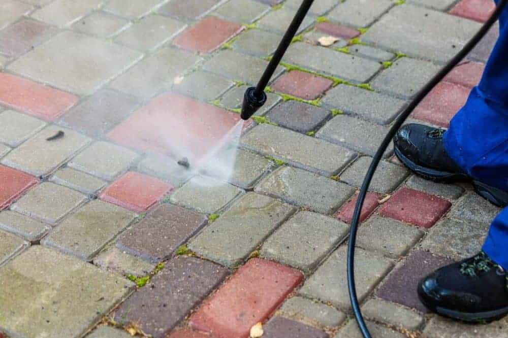 cleaning a brick patio with a power washer