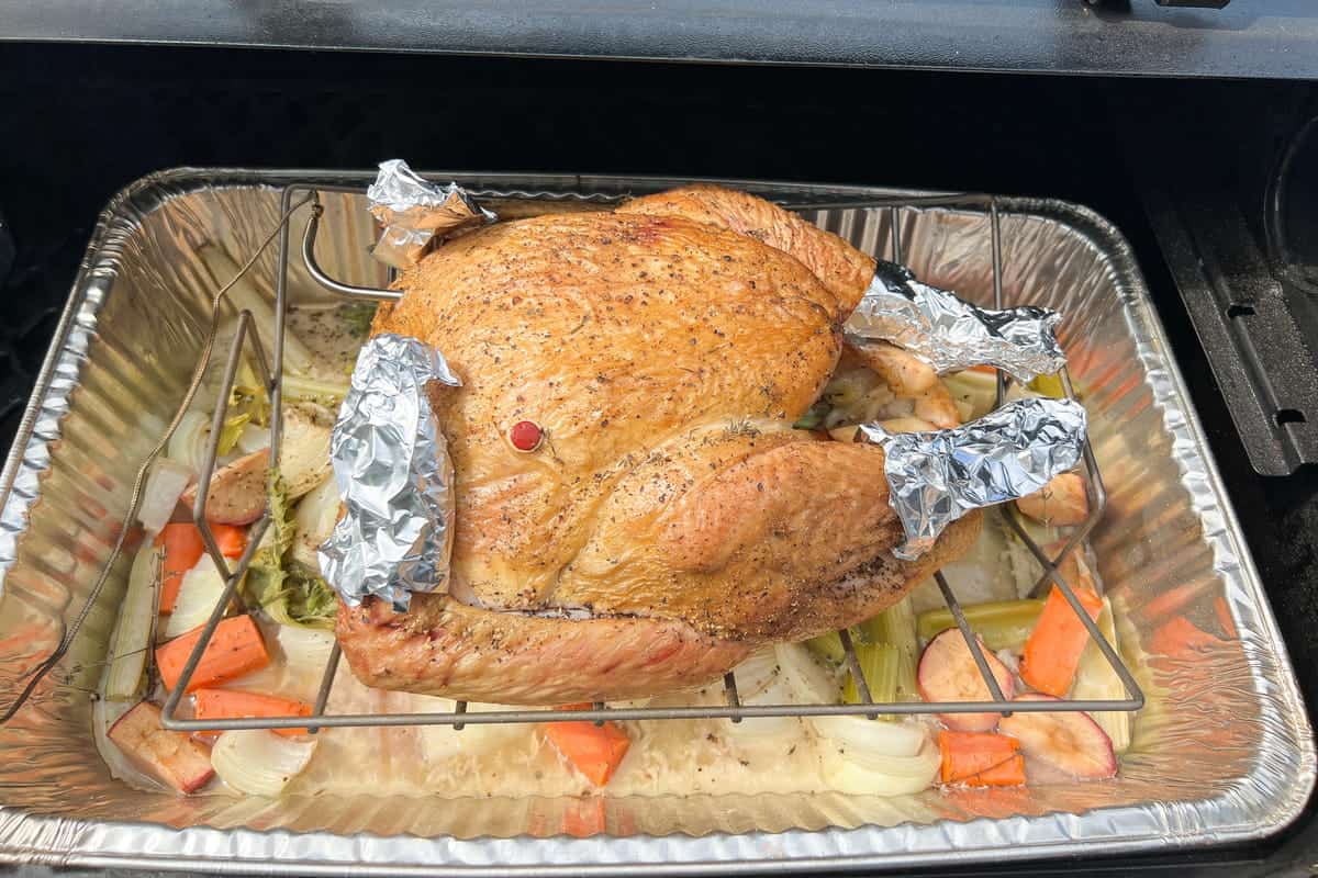 aluminum foil on the legs and wings of a turkey on the grill