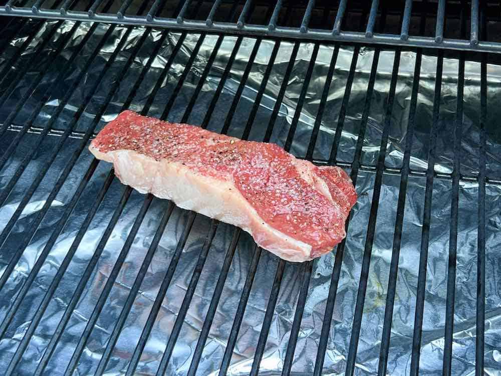 New York Strip steak on grates of ZGrills pellet grill