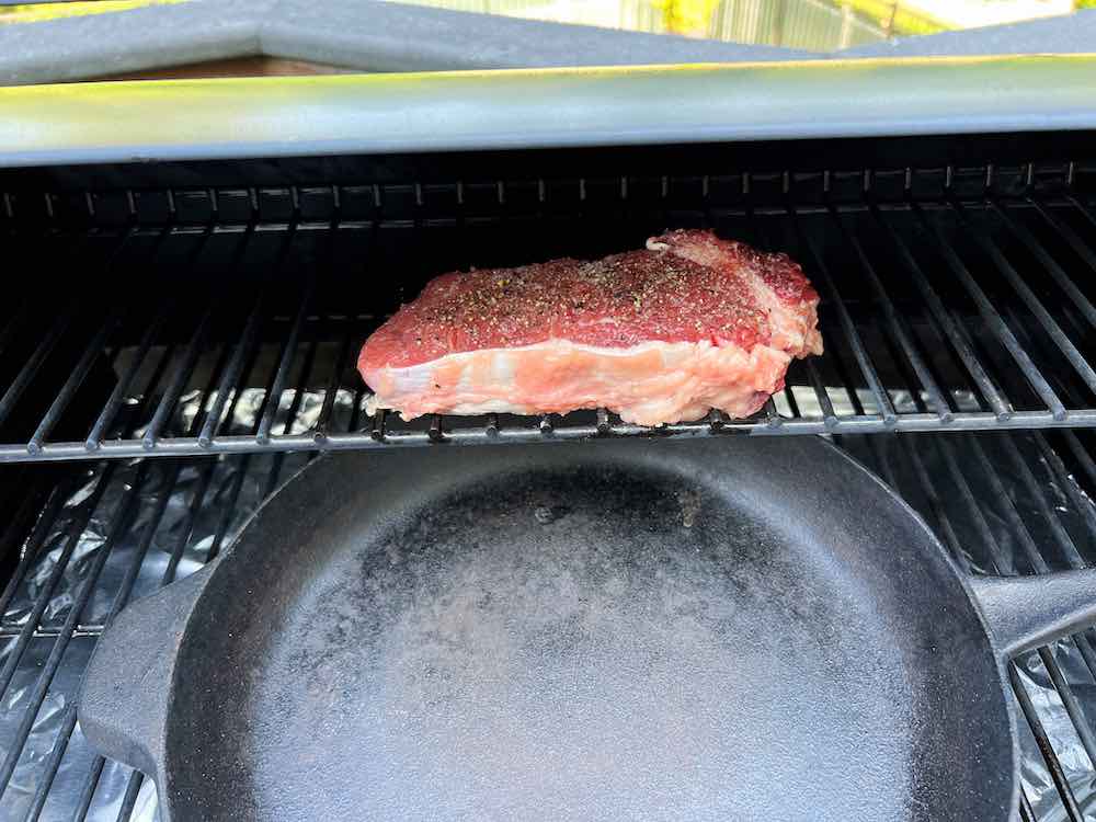 Steak cooking on top rack of ZGrills Pellet Grill over indirect heat