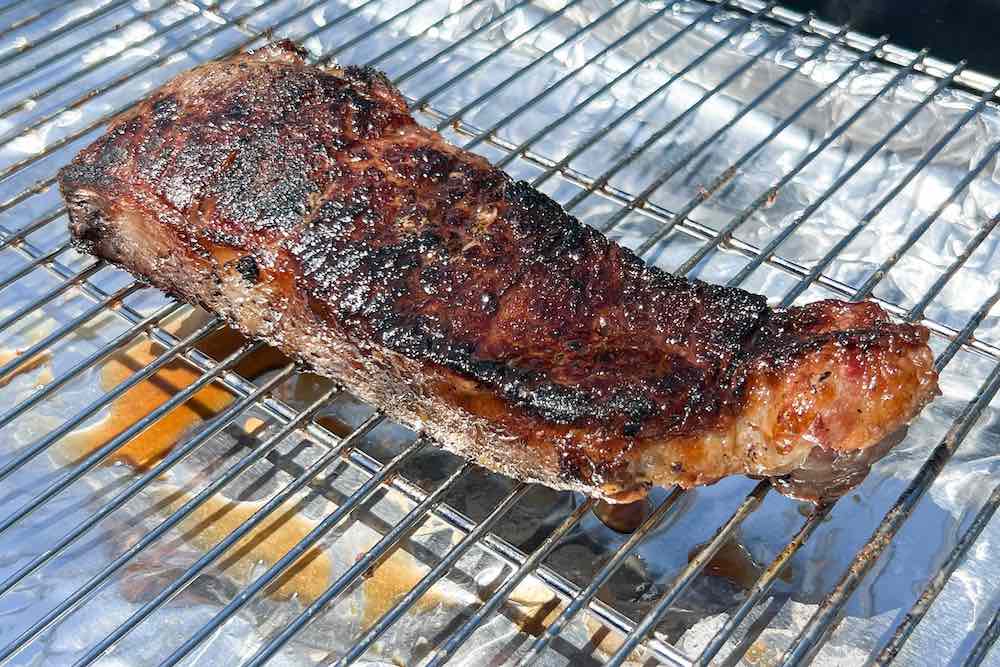 Finished seared steak resting on wire rack