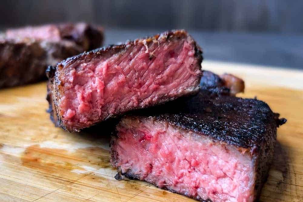 a steak seared on a pellet grill cut in half