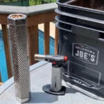 a photo of a pellet tube, a butane torch and a pellet bucket