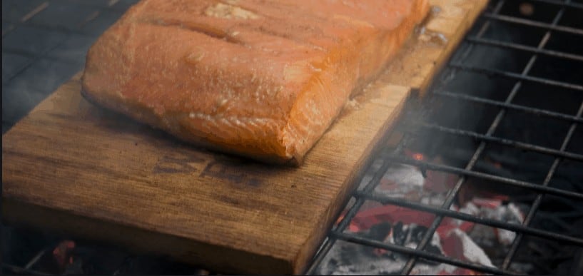 a piece of salmon on a cedar grilling plank