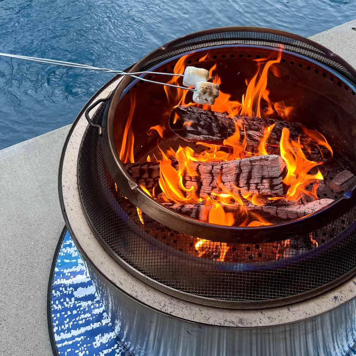a solo stove fire pit with a marshmallow roasting on a metal stick