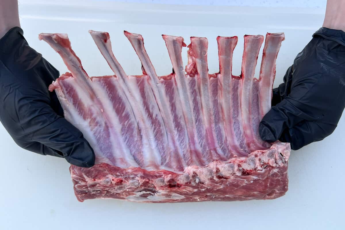 a rack of lamb being held up with the bones in the air