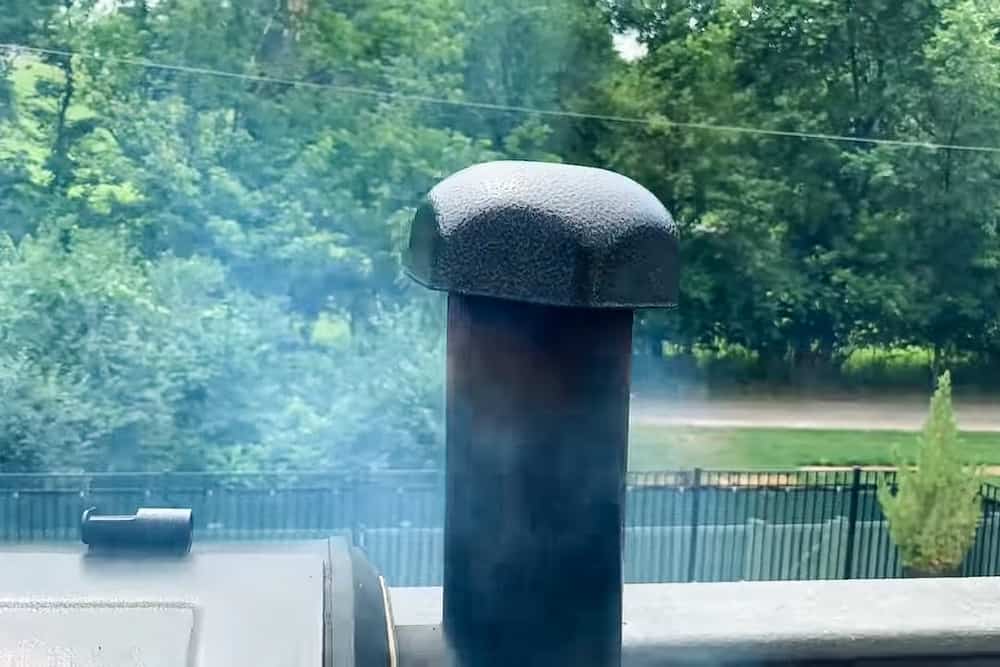 Pit Boss Pellet Grill Exhaust Tube with the cap in the down position with smoke coming out