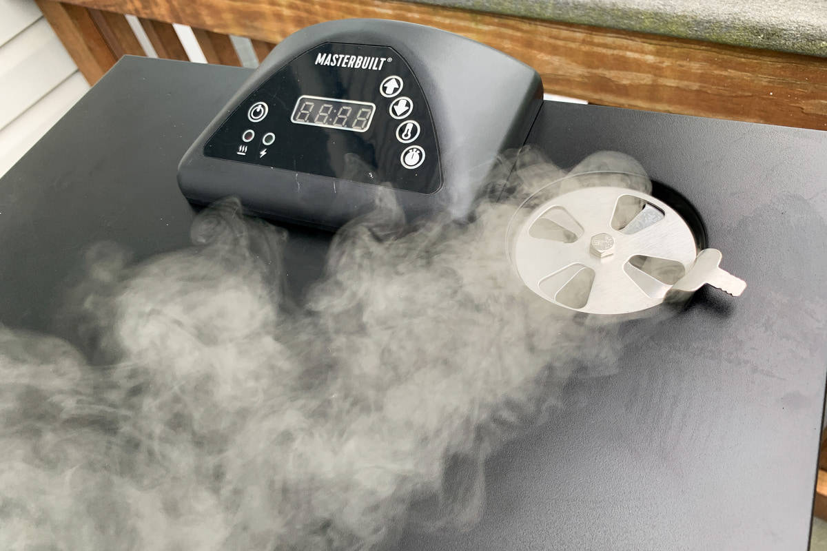 top vent of masterbuilt electric smoker with smoke coming out of it