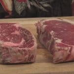 a ribeye and a new york strip steak on a cutting board