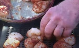 placing scallops in a grill basket in the smoker