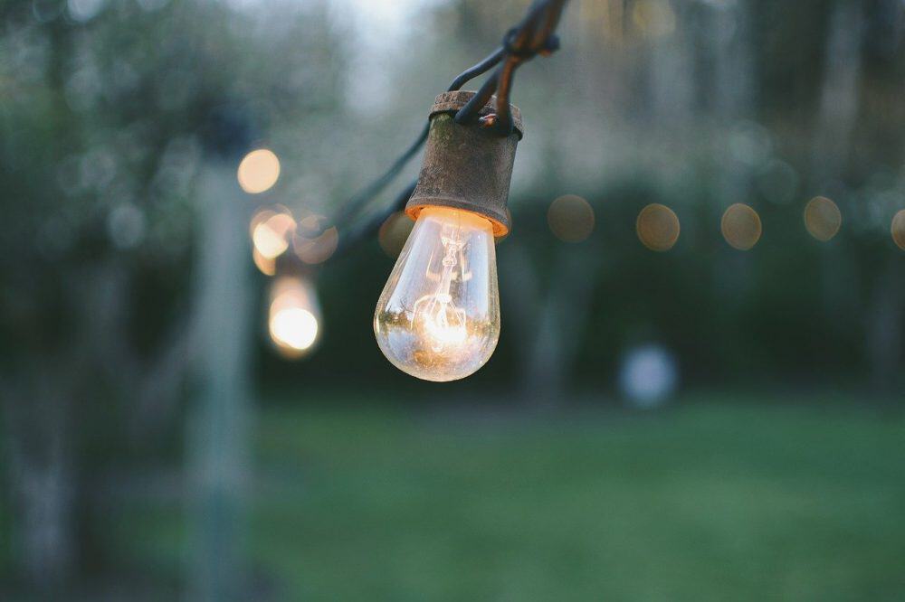 string lights hanging without nails stretched from a fence post