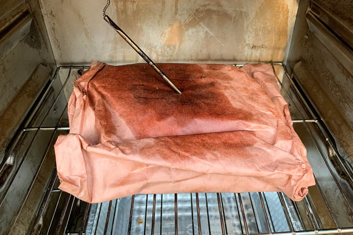 chuck roast wrapped in butcher paper inside a masterbuilt electric smoker