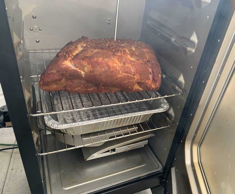 a pork butt smoking in a masterbuilt electric smoker