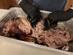 shredding a pork butt with bear claws into pulled pork