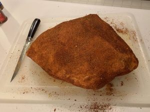 a seasoned pork butt on a cutting board