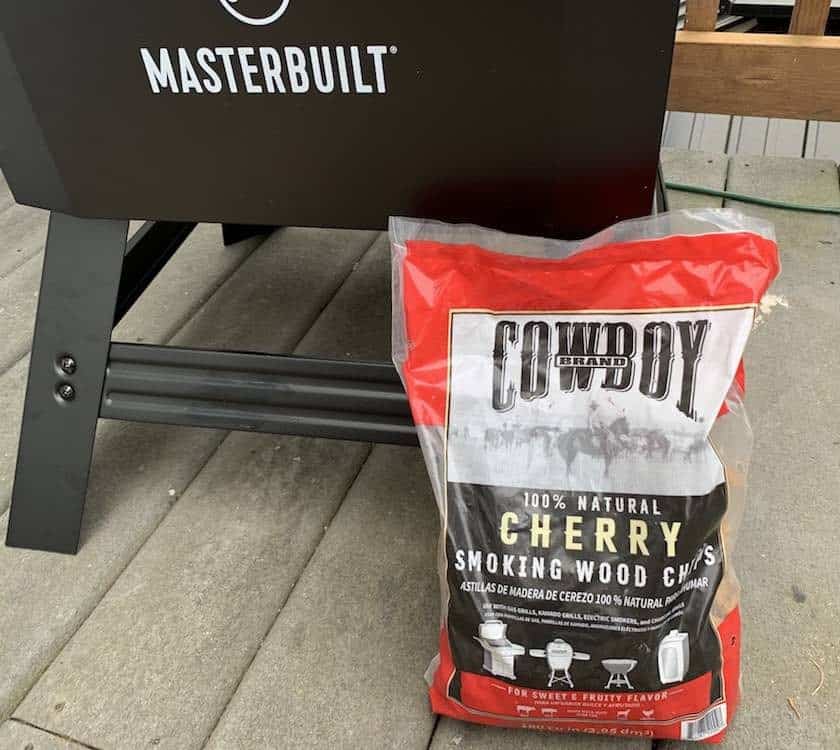 a bag of sherry wood chips leaning up against a masterbuilt electric smoker