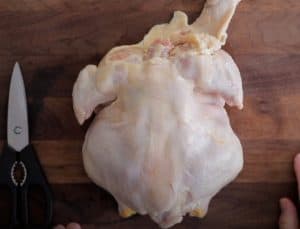a raw chicken about to be spatchcocked