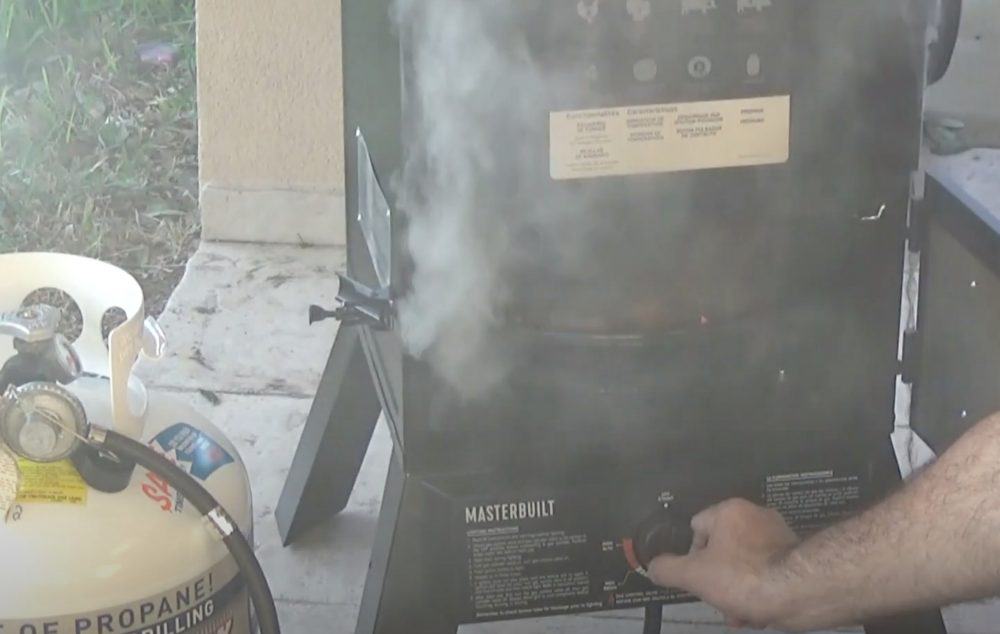 adjusting the thermostat control knob on a masterbuilt propane smoker