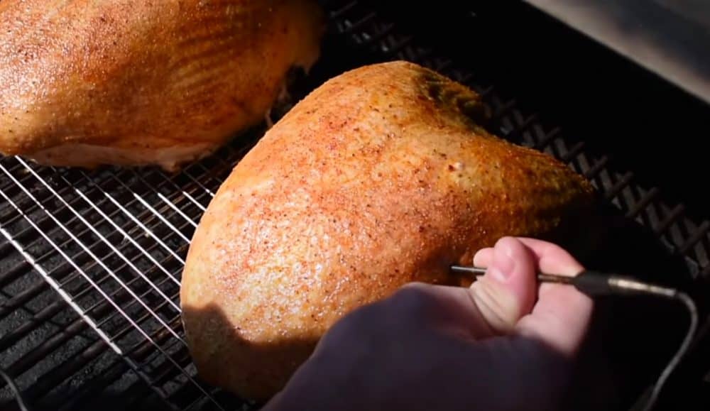 checking the temperature of a turkey breast on a pellet grill