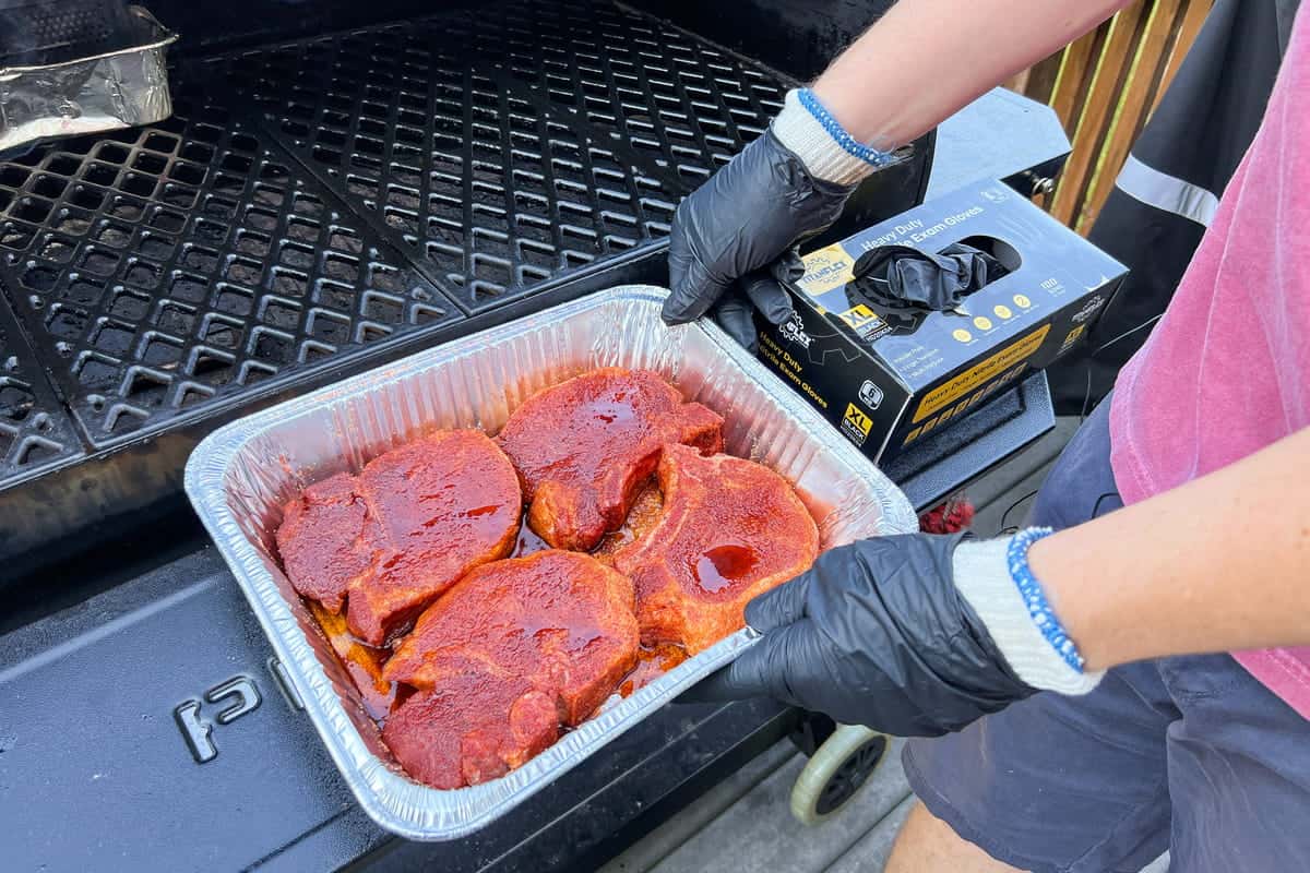 pork chops seasoned with rub in a pan that have moisture drawn out