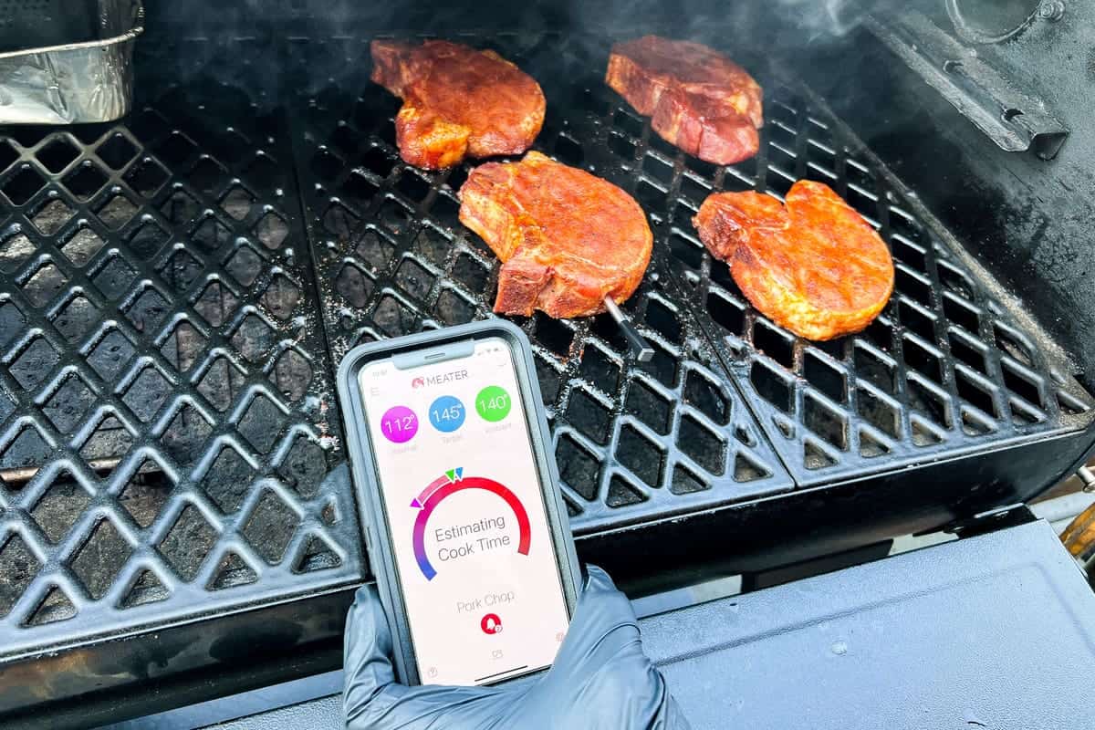 MEATER thermometer in pork chops with a smart phone showing the MEATER app data