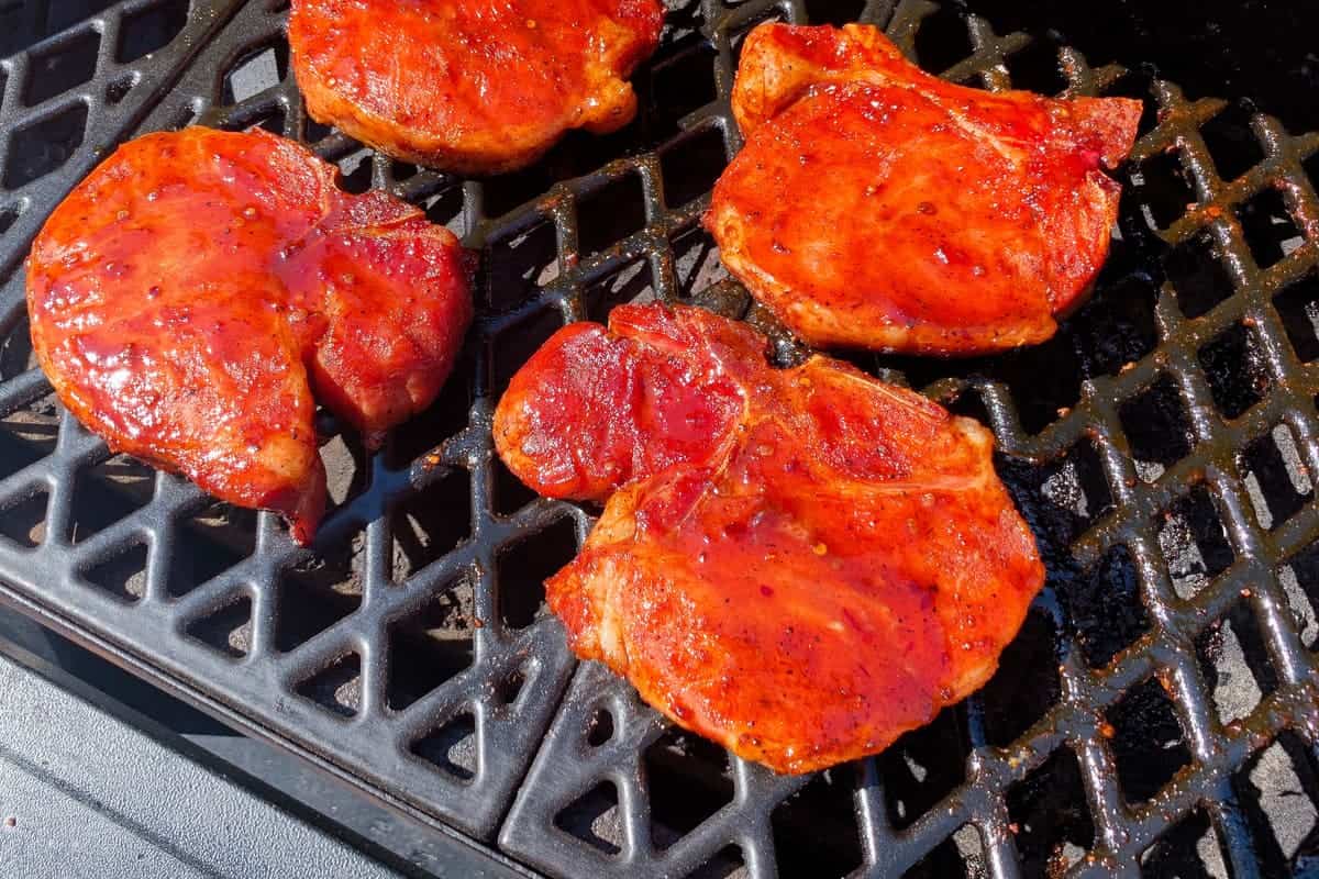 finished pork chops on the grates of a pellet grill