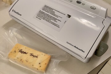 a block of pepper jack cheese being vacuum sealed in a bag