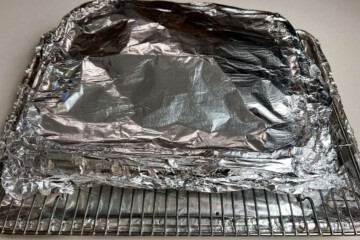 an aluminum foil covered aluminum foil pan on a wire rack