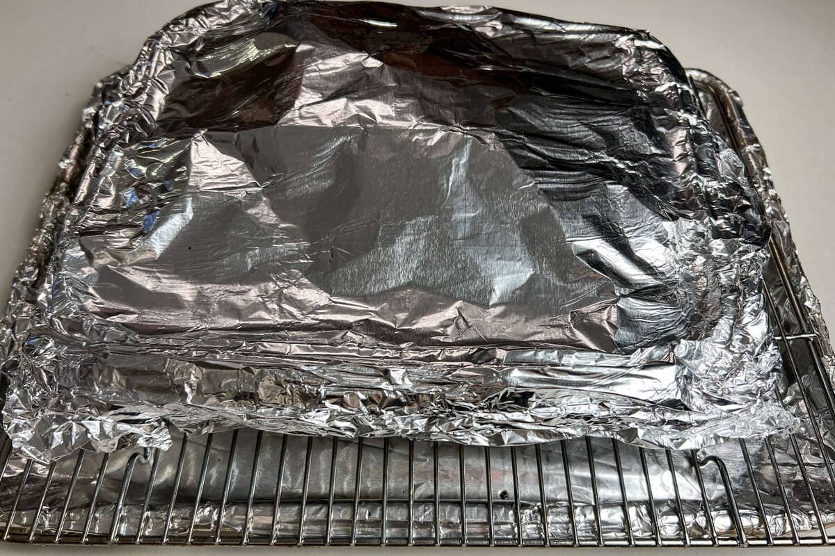 an aluminum foil covered aluminum foil pan on a wire rack