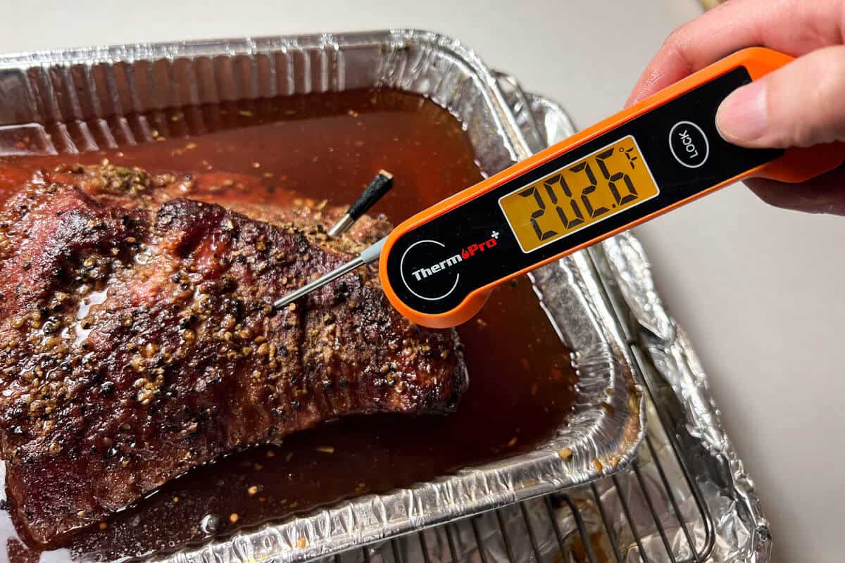 an instant read thermometer inside a corned beef brisket reading 202.6 degrees F