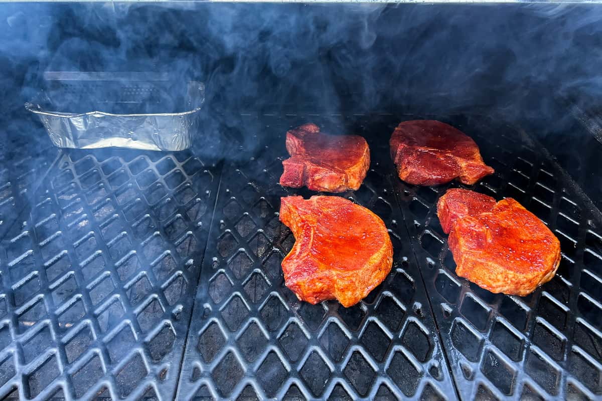 pork chops positioned on the right side of a pellet grill away from the hottest portion of the grill