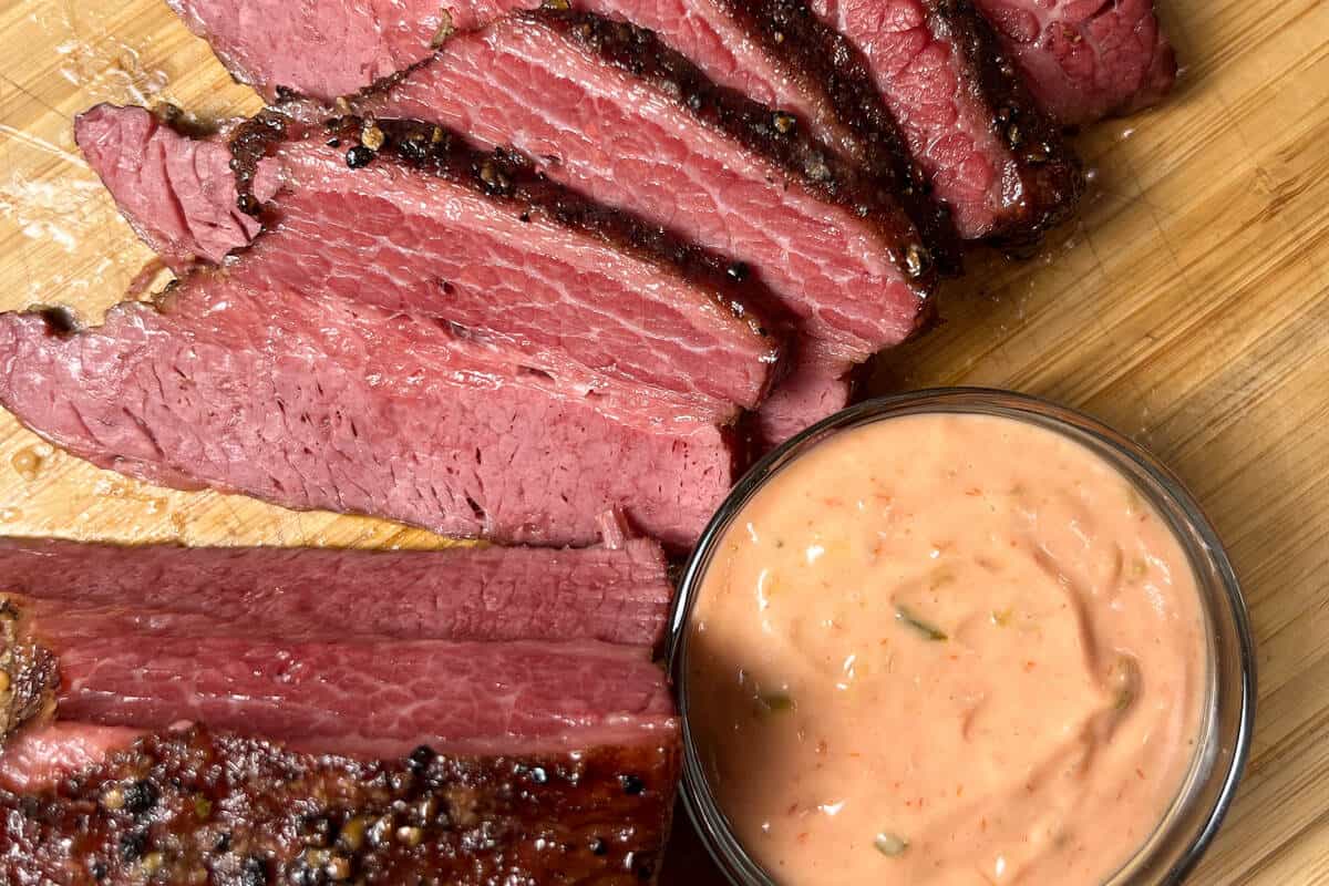slices of corned beef next to a small bowl of Thousand Island Dressing