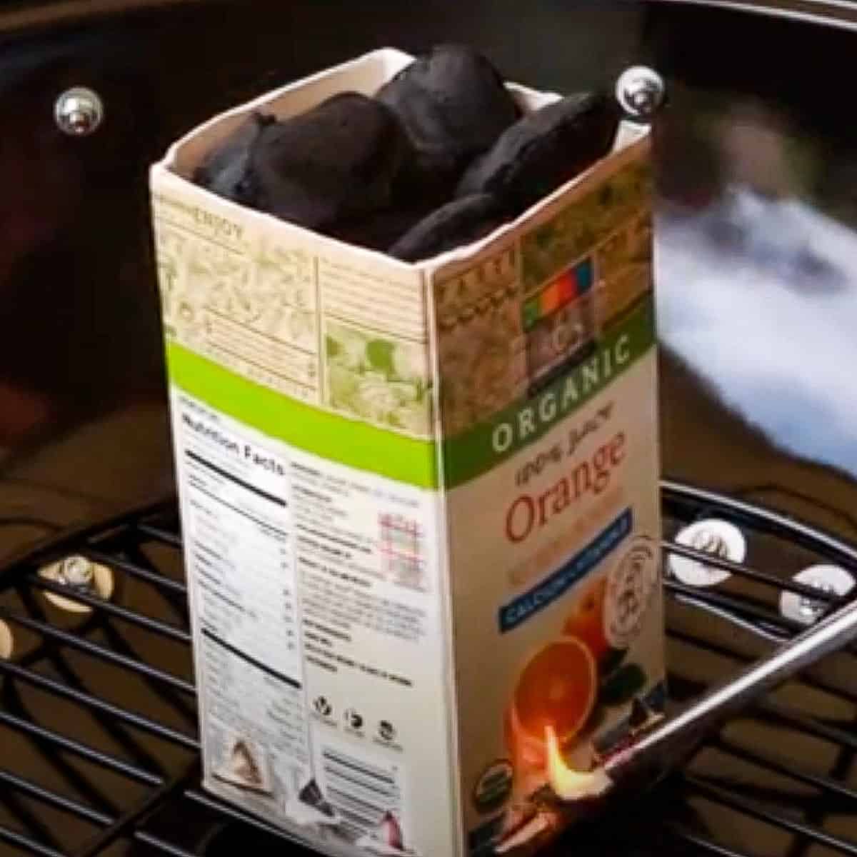 DIY charcoal chimney made of an empty tea box with charcoal inside