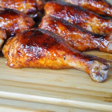 chicken legs made on a pit boss pellet grill on a wooden cutting board