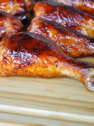 chicken legs made on a pit boss pellet grill on a wooden cutting board