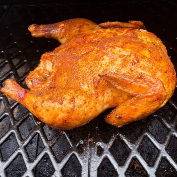 smoked whole chicken on the grates of a pit boss pellet grill