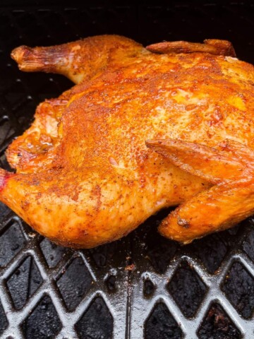 smoked whole chicken on the grates of a pit boss pellet grill