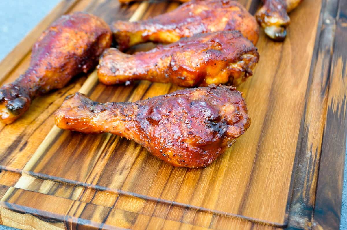 electric smoker smoked chicken legs on a cutting board