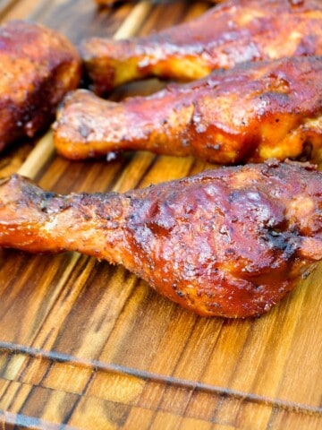 electric smoker smoked chicken legs on a cutting board