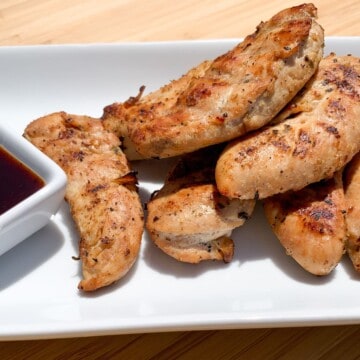 Smoked Chicken Tenders on a white plate with a bbq dipping sauce