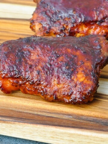 electric smoker chicken thighs on a cutting board