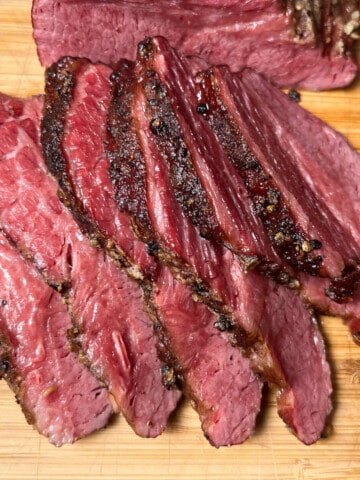 slices of smoked corned beef brisket on a wooden cutting board