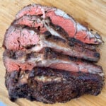 Smoked prime rib sliced on a wooden cutting board
