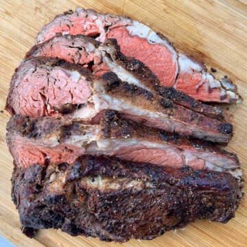 Smoked prime rib sliced on a wooden cutting board