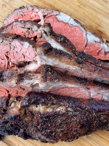 Smoked prime rib sliced on a wooden cutting board