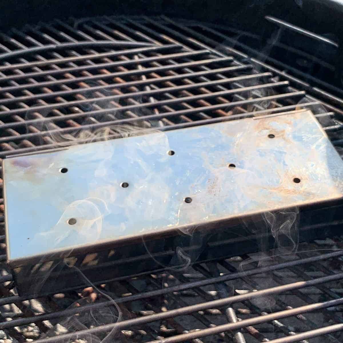 a smoker box on a charcoal grill