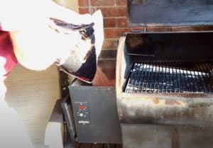 pouring pellets into a traeger pellet grill hopper