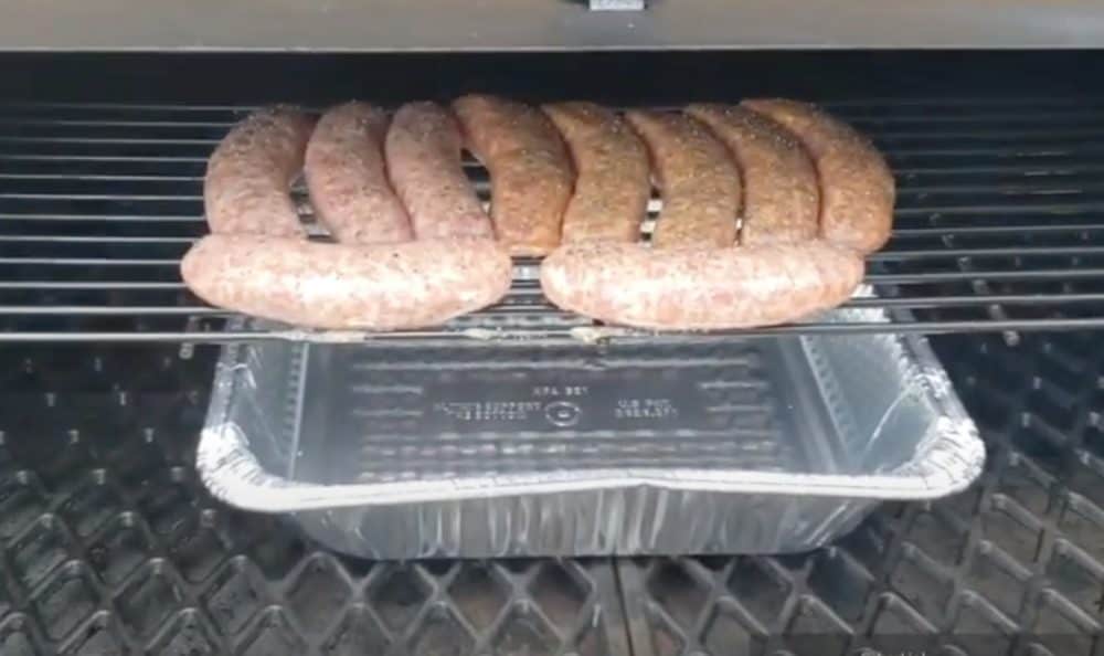 raw brats just placed on a pellet grill