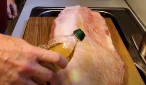 rubbing oil on a brisket to hold rub